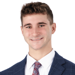 A headshot of associate Andrew Bass. He has short brown hair and is wearing a navy blue suit.