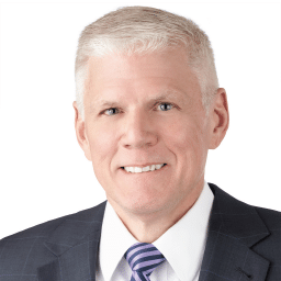 A headshot of associate Andrew Keefer. He has short white hair and is wearing a black suit.