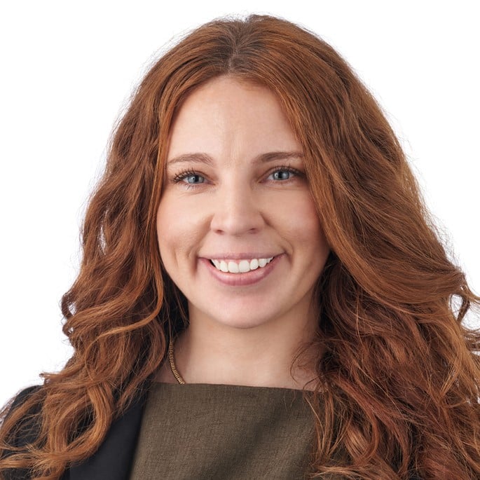 A headshot of associate Abigail Miller. She has long red hair and is wearing a black blazer.