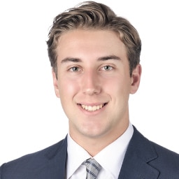 A headshot of associate Derek Jordan. He has short blonde hair and he is wearing a navy blue suit.