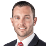 A headshot of associate Andrew Davis. He has short brown hair and he is wearing a black suit.