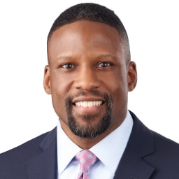 A headshot of associate Donald Lyons. He has short black hair and he is wearing a navy blue suit.