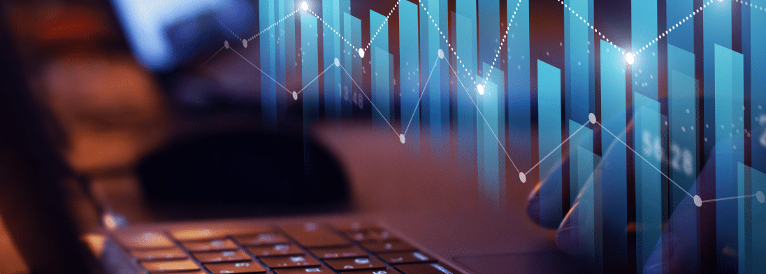 An image depicting line and bar charts in front of a laptop keyboard.