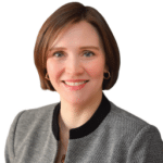 A headshot of associate Elizabeth Wagner. She has short brown hair and is wearing a gray cardigan sweater.