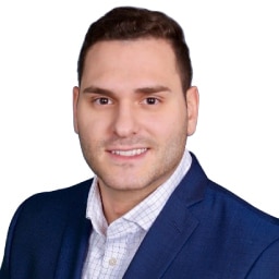 A headshot of associate Anthony Feudo. He has short brown hair and he is wearing a blue suit.