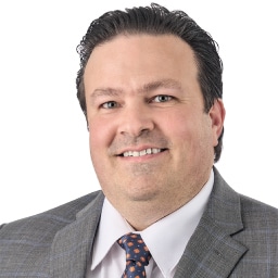 A headshot of associate John Walters. He has short black hair and is wearing a gray blazer.