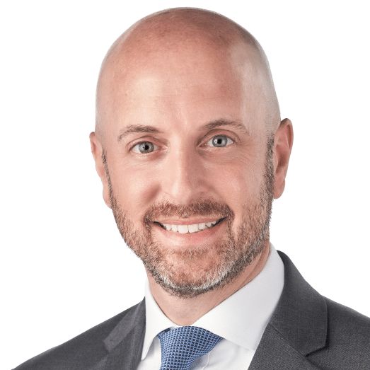 A headshot of associate David Navarro. He is smiling at the camera and wearing a gray suit.