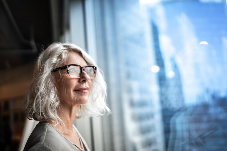 A woman looking out the window at a city skyline.