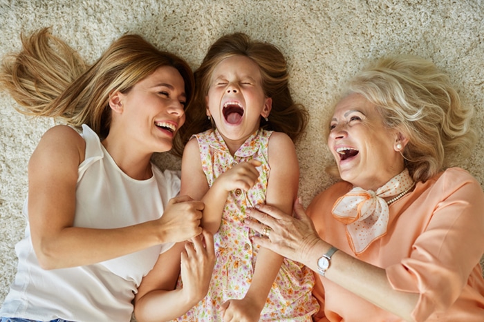 Three generations of a family laughing together.