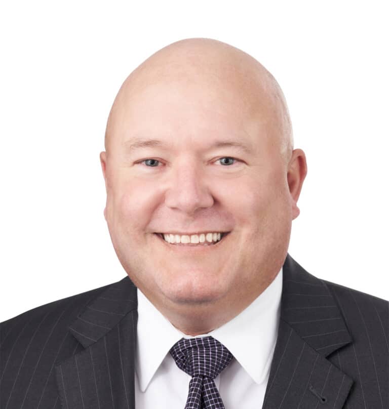 A headshot of associate Judson Embree. He is smiling at the camera and wearing a pinstriped suit.