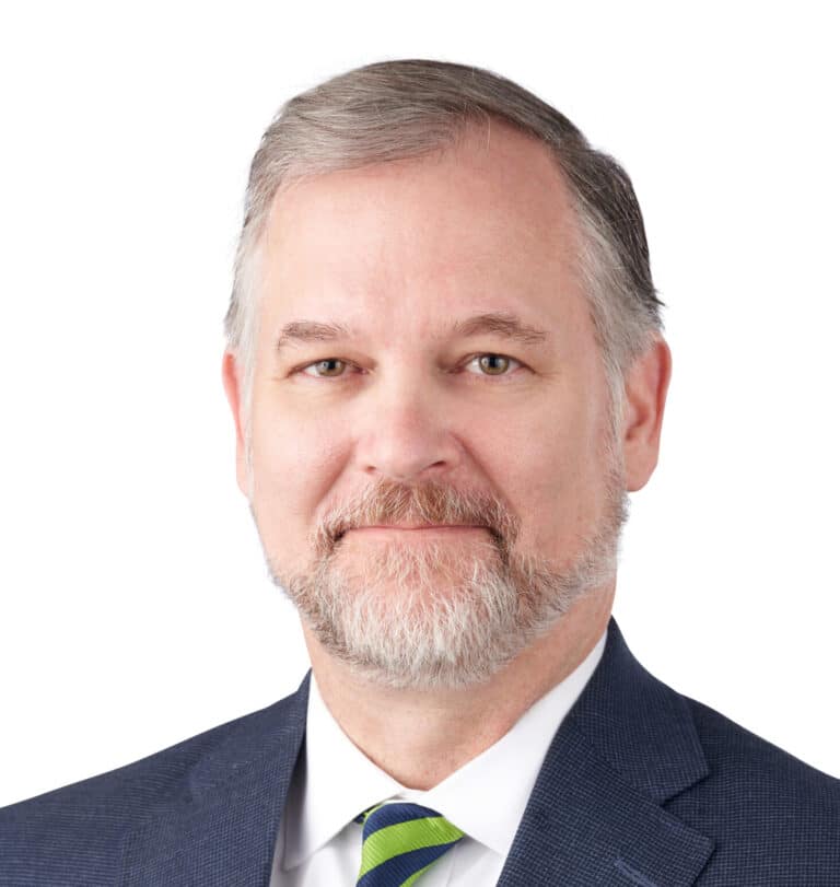 A headshot of associate Mark Bradford, CFP, ChFC, CRPC, AEP, AWMA. He has short gray hair and is wearing a navy blue suit.