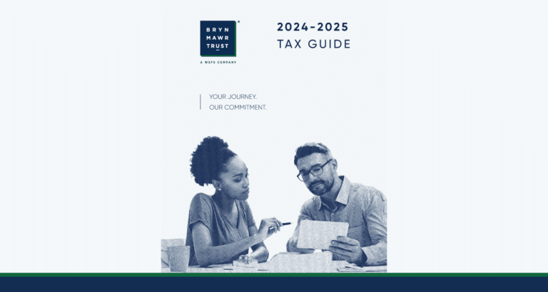 Two people sitting at a table reading the 2024-2025 Bryn Mawr Trust Tax Guide