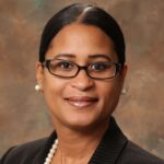 A headshot of associate Michelle Jones. She has black hair, black eyeglasses, and is wearing a pinstriped blazer.