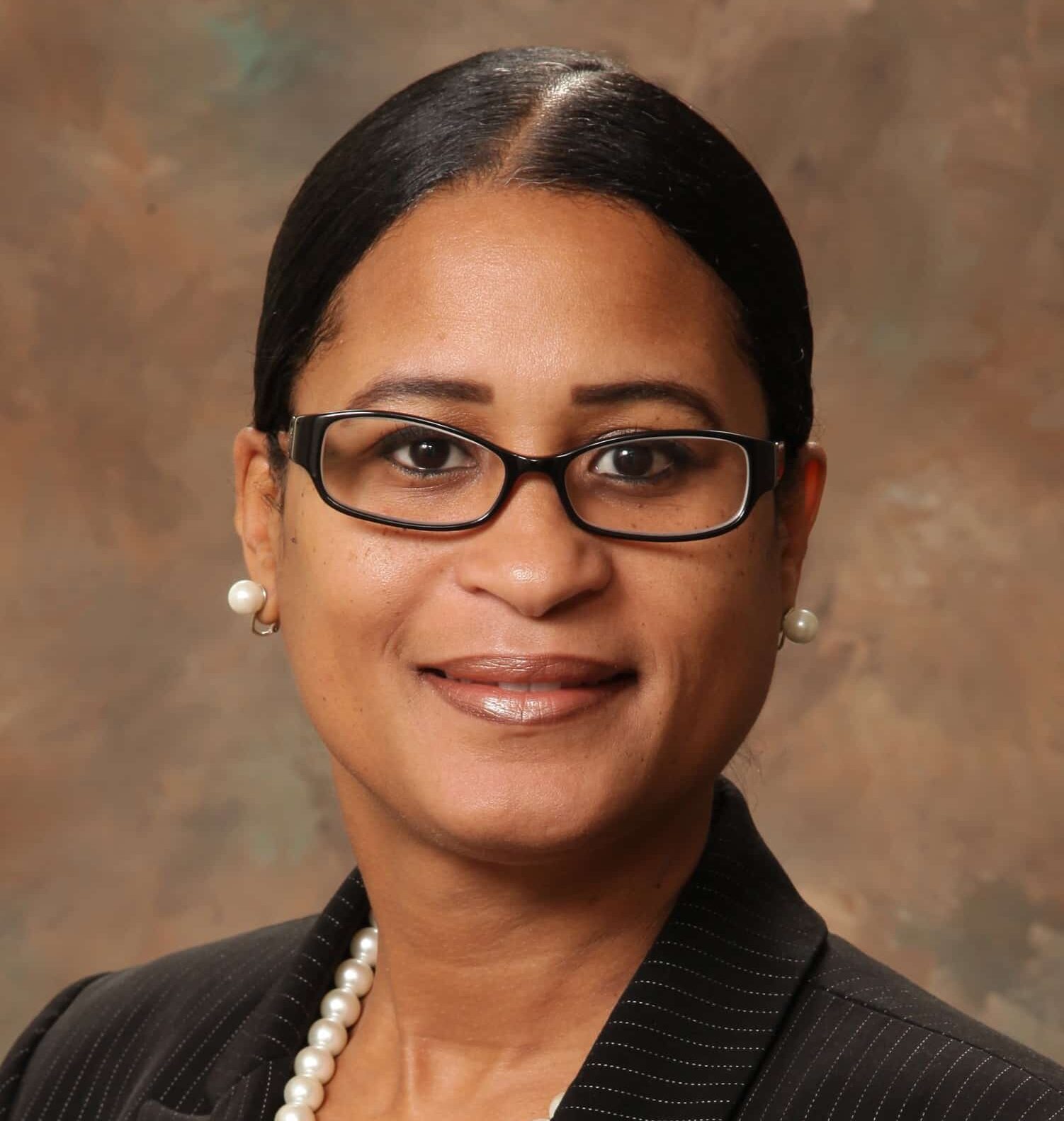 A headshot of associate Michelle Jones. She has black hair, black eyeglasses, and is wearing a pinstriped blazer.