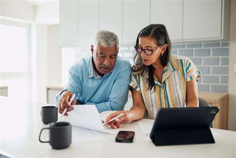 Two people sitting at a table reviewing their finances.