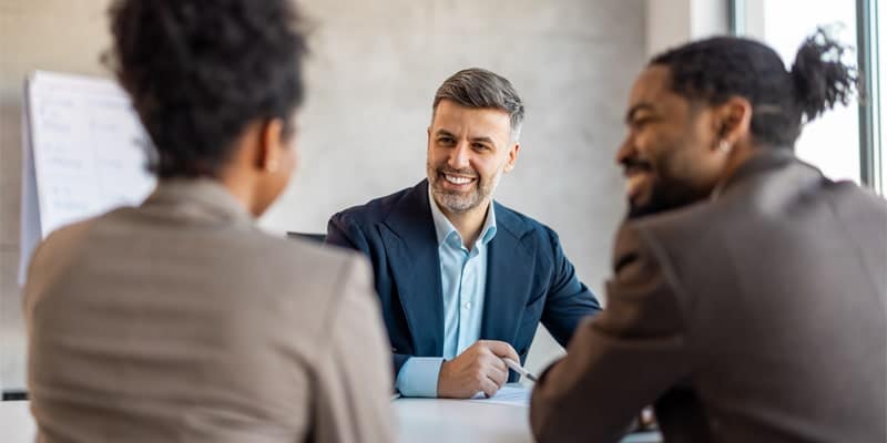 A group of professionals sitting around a desk.